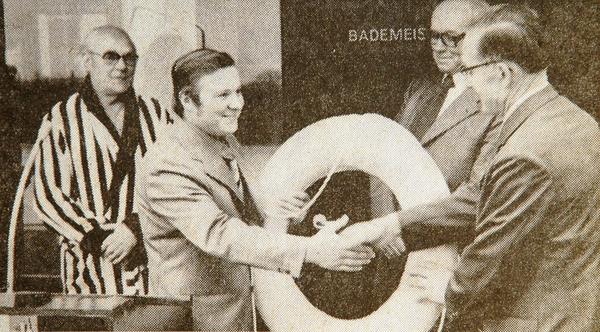 Samtgemeindebürgermeister Hermann Schnackenberg überreicht Johann Schröder einen Rettungsring. Bademeister Hans Deppe (links) und Architekt Holst (rechts hinten) schauen interessiert zu